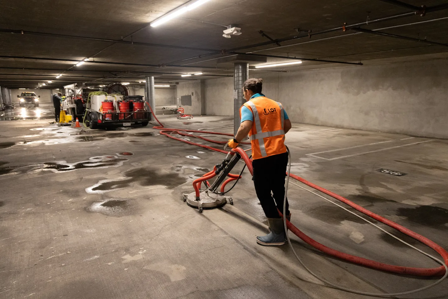 Technician using a surface cleaner on a parking garage floor